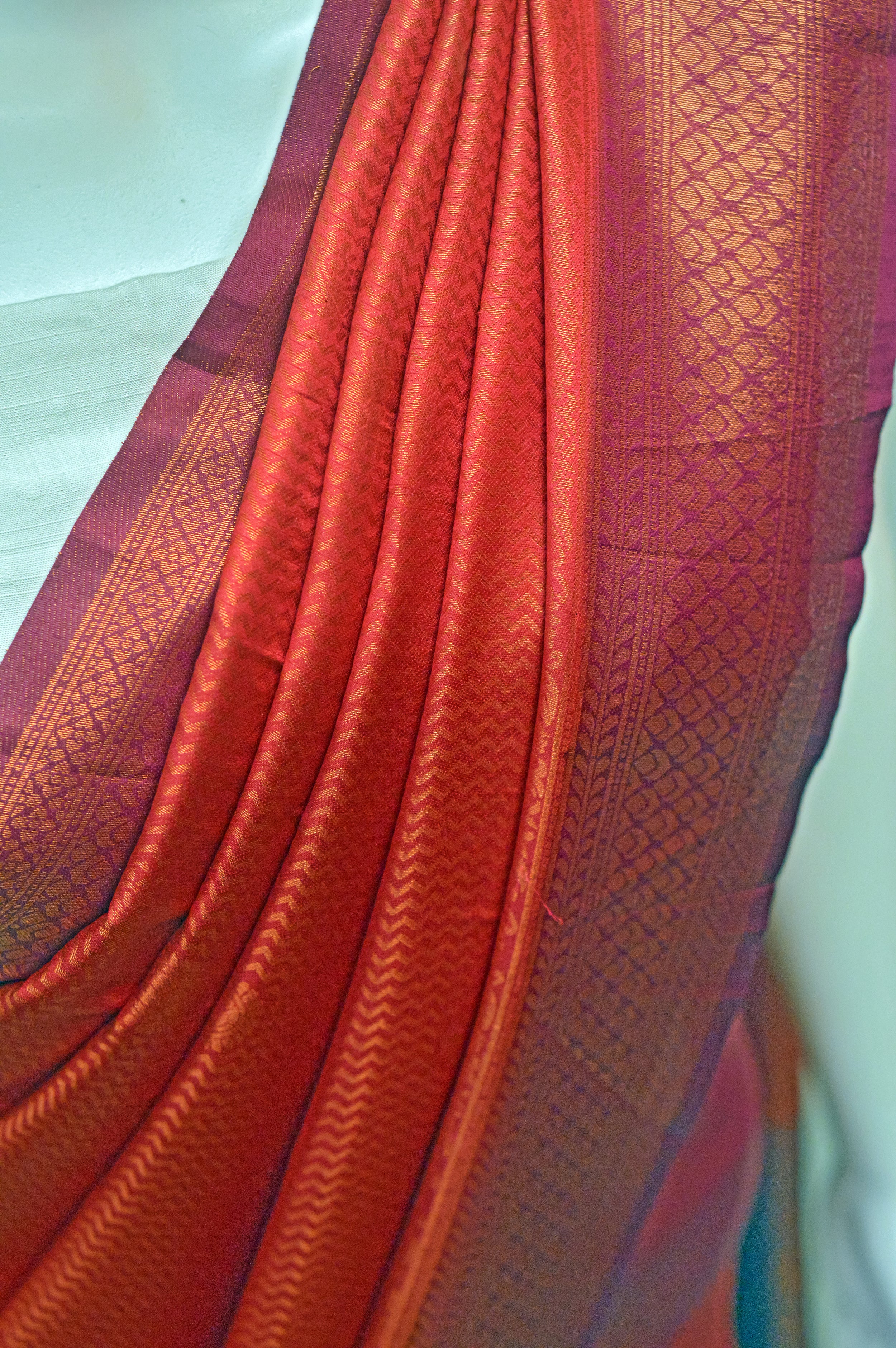 Kaloshmi samudrika pattu saree (silk, vibrant orange) Draped on a dummy at a studio setup -front view